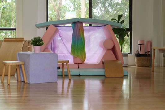 A pastel Funsquare play couch built into a fort with a rainbow canopy in a bright, modern living room