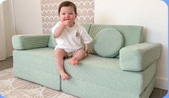 Baby sitting on a sage green Funsquare Mini play couch